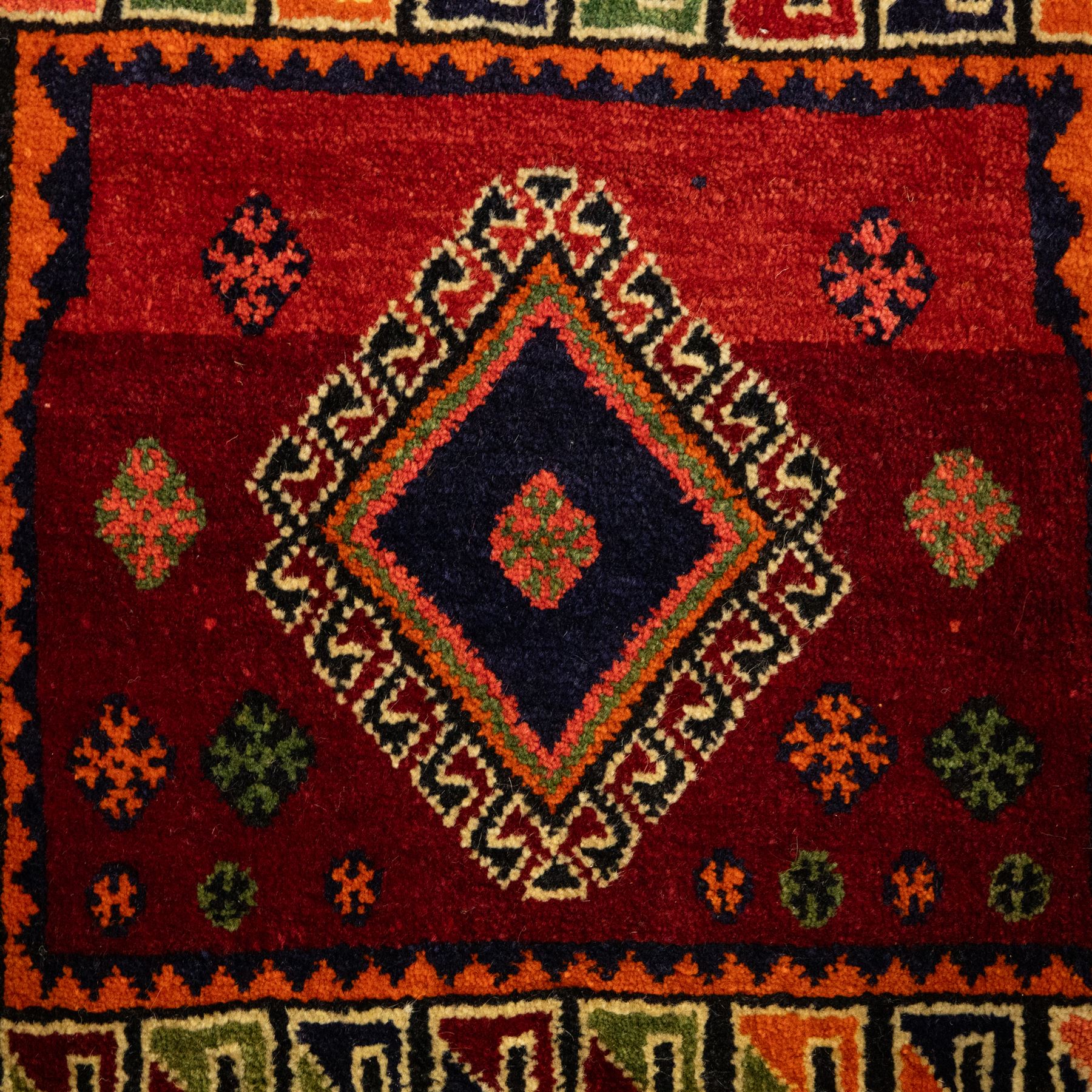 South West Persian Qashgai saddlebag, (Khorjin), woven in geometric designs with central lozenge medallions on a rich madder red ground, decorated with tribal motifs in indigo, ivory green, and ochre, the reverse  with panels of stripped flatwoven kilim 