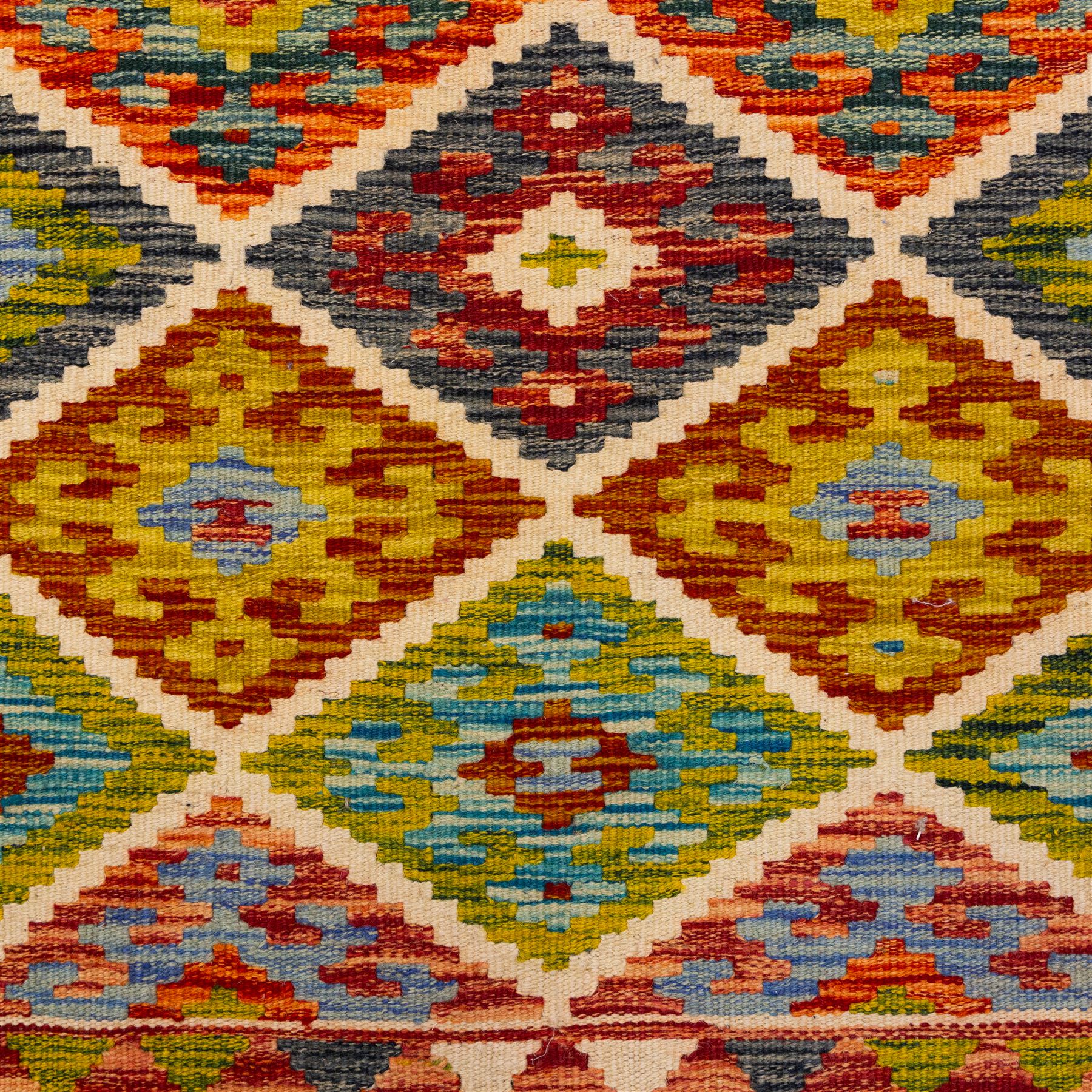 Turkish Anatolian flatweave kilim, ivory field decorated with rows of large stepped lozenge medallions enclosing stylized geometric motifs flanked by narrow geometric side panels, fringe ends 