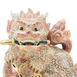 Temple Lion or Dog of Foo, modelled in seated post, one with one front paw resting upon a ball, with sword in mouth, H58cm