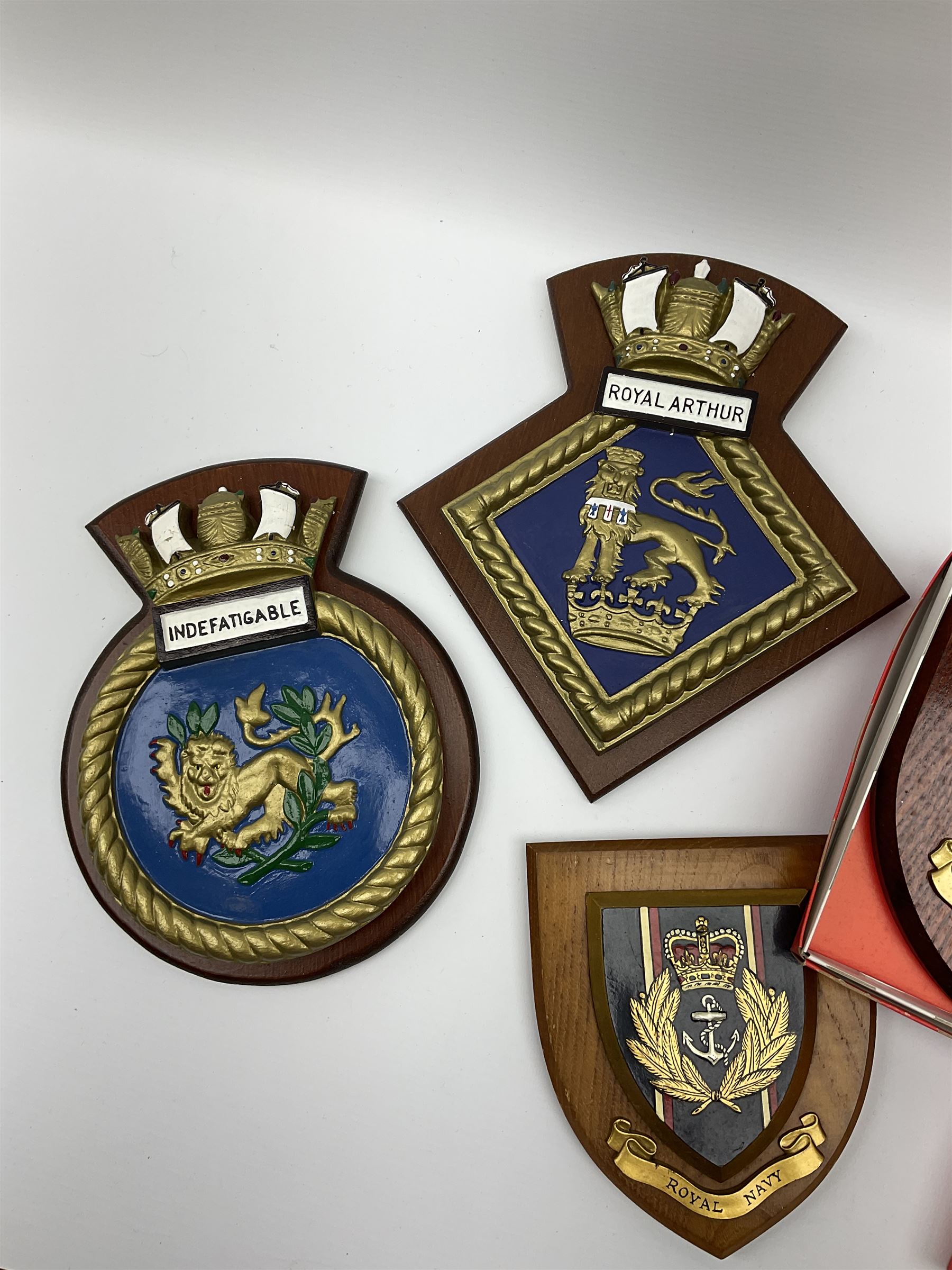 Various Navy wooden heraldic shields each with hand painted raised shield, including HMS Indefatigable, HMS Nelson,  HMS Victory etc, ten in total.  