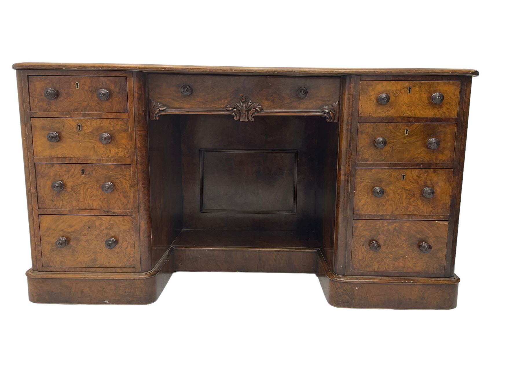 Victorian figured walnut kneehole desk, moulded rectangular top with inset leather writing surface, fitted with nine drawers, the central frieze drawer with carved curled foliage mount, on moulded plinth base,