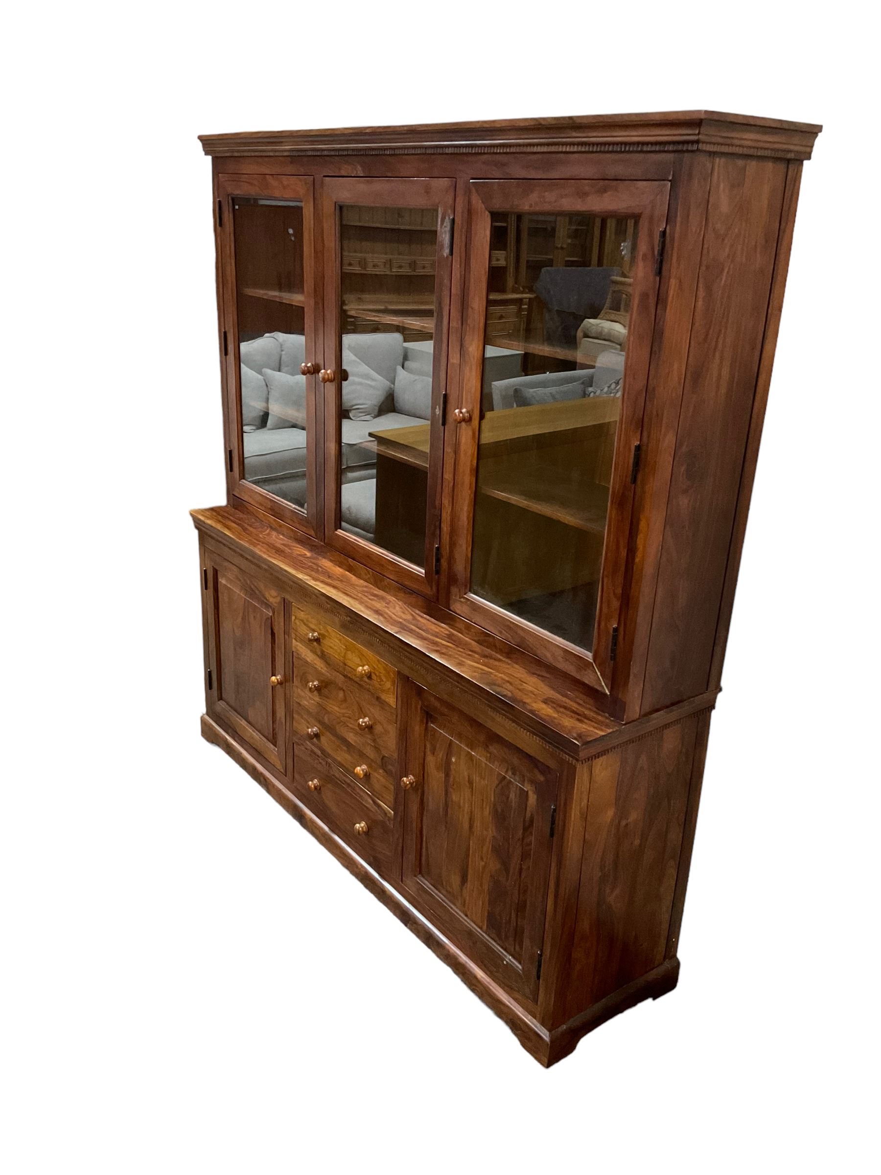 Large hardwood display wall unit, the upper section fitted with three glazed doors enclosing six shelves, the lower section fitted with four central drawers flanked by two panelled cupboards