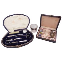 Silver handled manicure set including nail file, buffer and pill box, hallmarked, with two pairs of stainless steel scissors, cased, a set of continental silver enamelled teaspoons, stamped 800, boxed, and silver lidded glass jar, hallmarked 