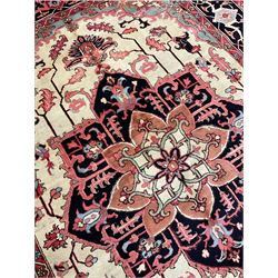 North West Persian Heriz carpet, ivory ground with large central medallion and floral spandrels, triple band border with scrolling design decorated with flower head and plant motifs 