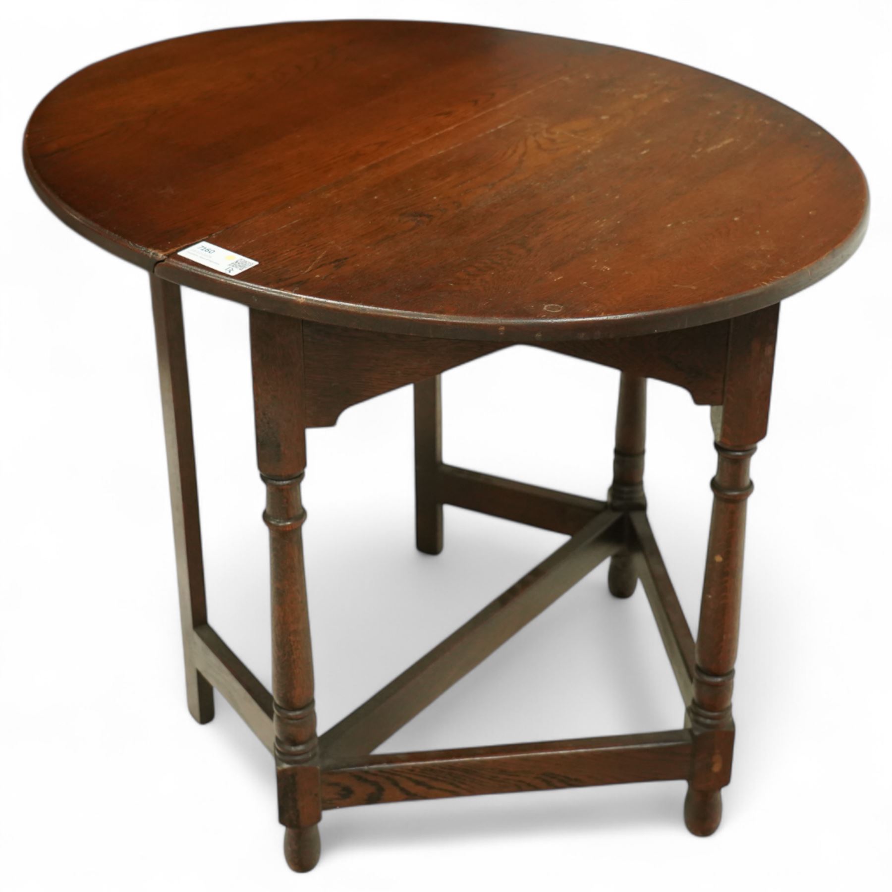 20th century oak drop-leaf table, of gateleg form with oval top, raised on turned legs and stretchers with twin gate supports