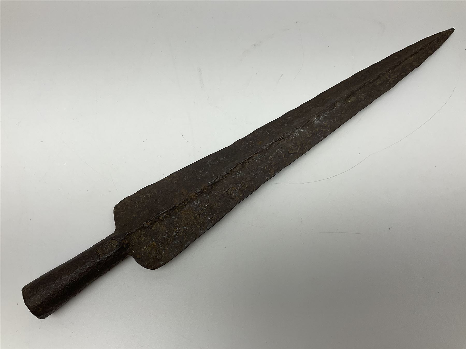 19th century continental folding knife with 15.5cm single edged blade, the pierced brass and iron handle with remains of horn grips L21.5cm overall closed; turned horn handled knife with foliate engraved blade; battlefield relic German 1884/98 knife bayonet; iron spear head; leather covered swagger stick; and two-piece gun cleaning rod