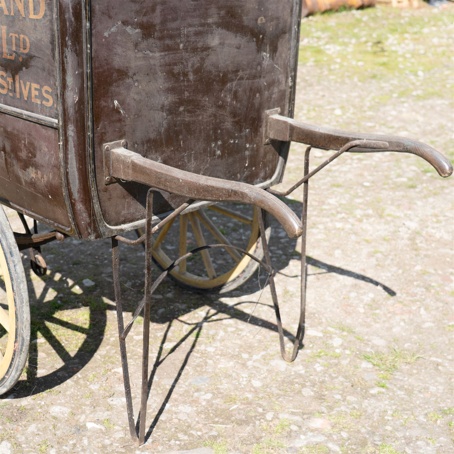 West of England Knitting Co. Ltd. Advertising Hand Cart

A rare and highly decorative late Victorian or Edwardian advertising hand cart, retaining its original black painted finish and gilt signwriting for West of England Knitting Co. Ltd., London, Penzance & St Ives. The enclosed box body is mounted on large cream painted wooden spoked wheels and fitted with rear push handles, allowing the cart to be manoeuvred by hand. Intended as a promotional and delivery vehicle for one of Britain's best known knitwear manufacturers, the cart survives as an evocative piece of commercial advertising history. The interior remains accessible via twin rear doors, while traces of the original maker's transfer for the Warwick Carrier are visible. An unusual and attractive display piece suited to collectors of advertising, transport memorabilia and social history.

Features

• Original hand painted gilt signwriting for West of England Knitting Co. Ltd.
• Advertising panels referencing London, Penzance and St Ives
• Enclosed wooden box body with twin rear access doors
• Original black painted finish with period lettering
• Large cream painted wooden spoked wheels with iron tyres
• Rear push handles for hand propelled operation
• Warwick Carrier maker's transfer remains visible
• Original undercarriage and running gear
• Attractive display piece with strong commercial advertising appeal
• Suitable for museum, retail, interior or collection display

Dimensions:
Overall length: 190 cm
Body length: 125 cm
Overall width: 140 cm
Body width: 100 cm
Height: 150 cm

Wheel Diameter:
Wheels: 92 cm