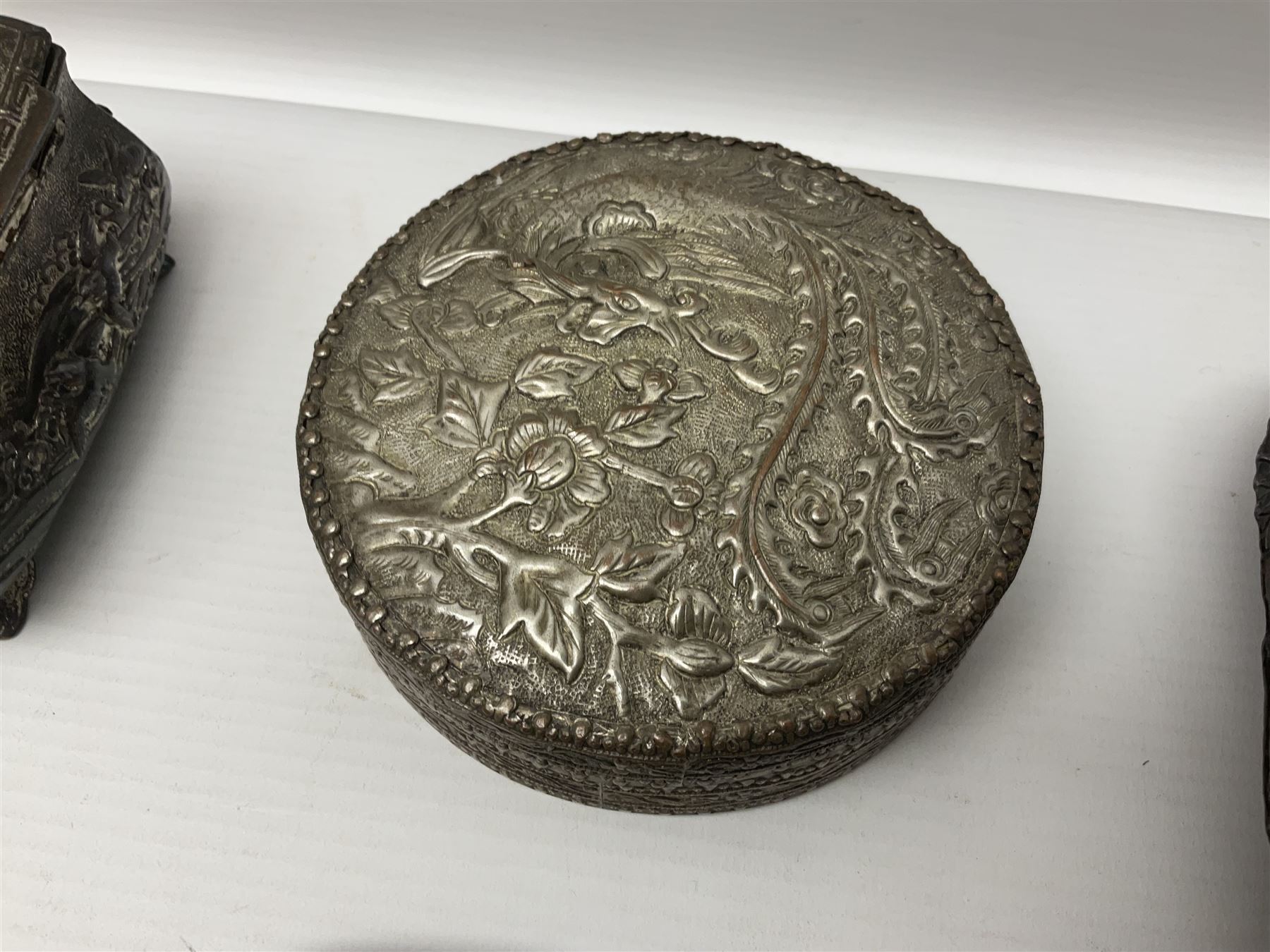 Brass sunfish ashtray, Chinese silver plated trinket box with mirror, bronzed matchbox cover and a collection of other Oriental bronzed embossed metal trays