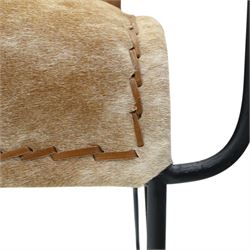 Mid century style cocktail cowhide chair, upholstered in tan cowhide, rectangular back and curved seat with stitched panels and laced borders, shaped wooden armrests on curved black metal supports 