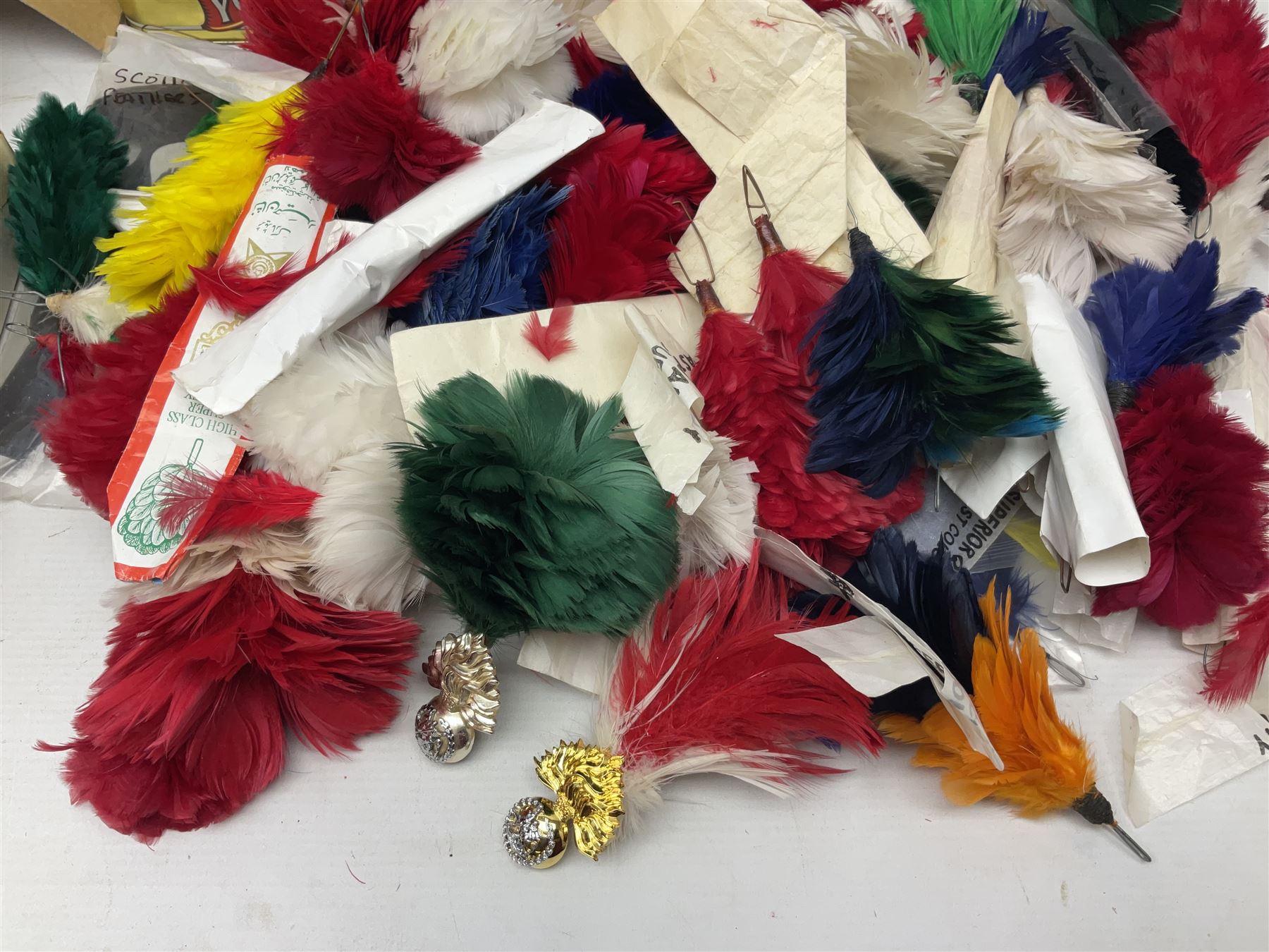 Quantity of military horse hair plumes and feather hackles, cloth stripes and regimental titles etc