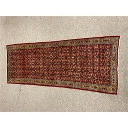Persian red ground rug, the field decorated with repeating Herati motif's 