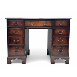 Georgian design mahogany kneehole desk, moulded rectangular top with red gilt-tooled leather writing surface, over an arrangement of nine cock-beaded drawers with brass swan neck handles, on bracket feet