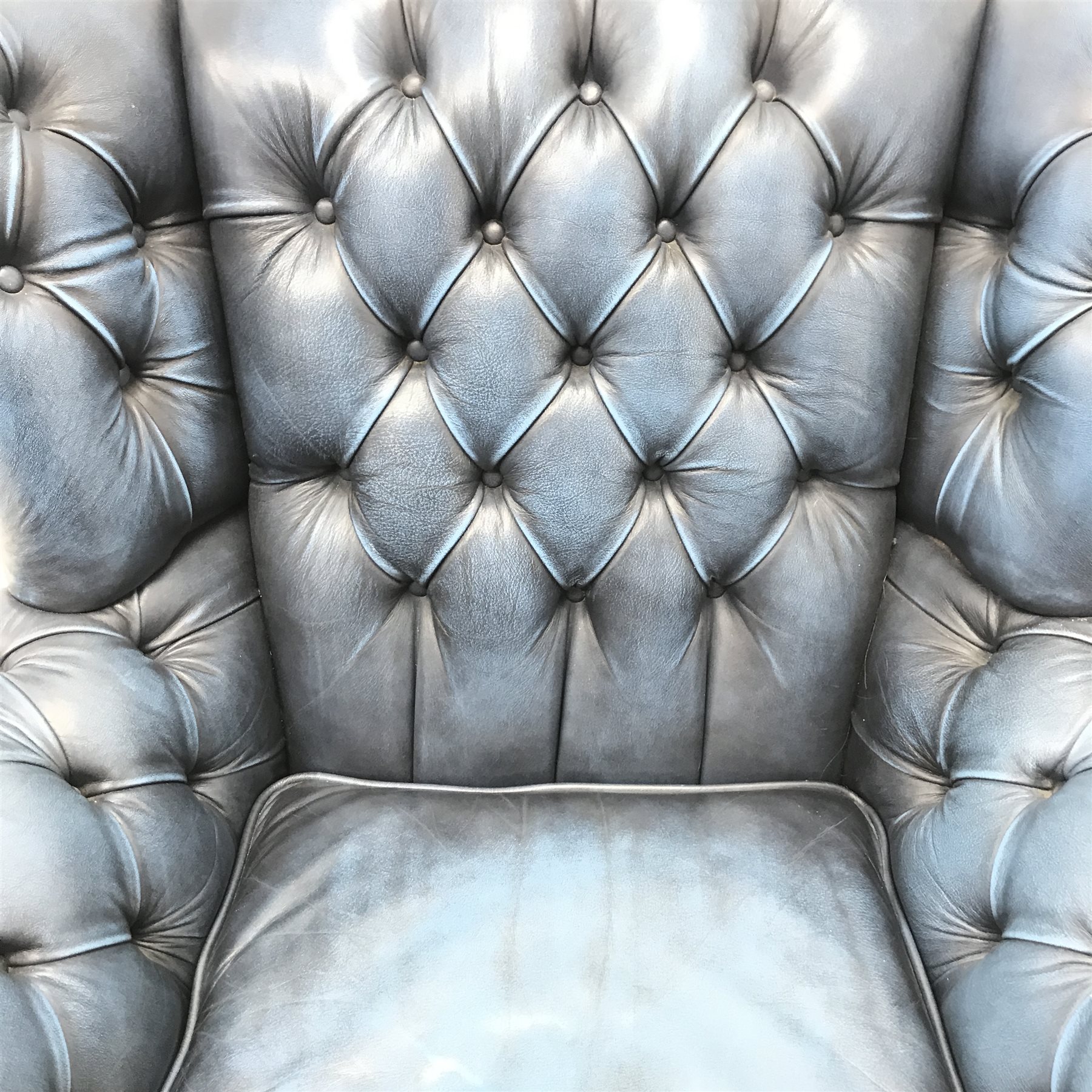 style wingback armchair upholstered in a deep buttoned blue