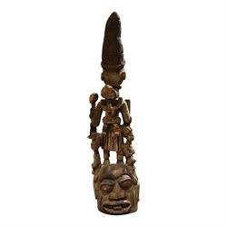 African tribal maternity figure of a woman with children, probably Yoruba, carved wood, the woman stood upon a craved mask, H133cm