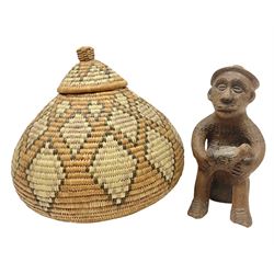 Native naive terracotta figure of a man seated on a stool cradling a bird, H20cm together with a Zulu wedding basket with certificate signed by the weaver (2)