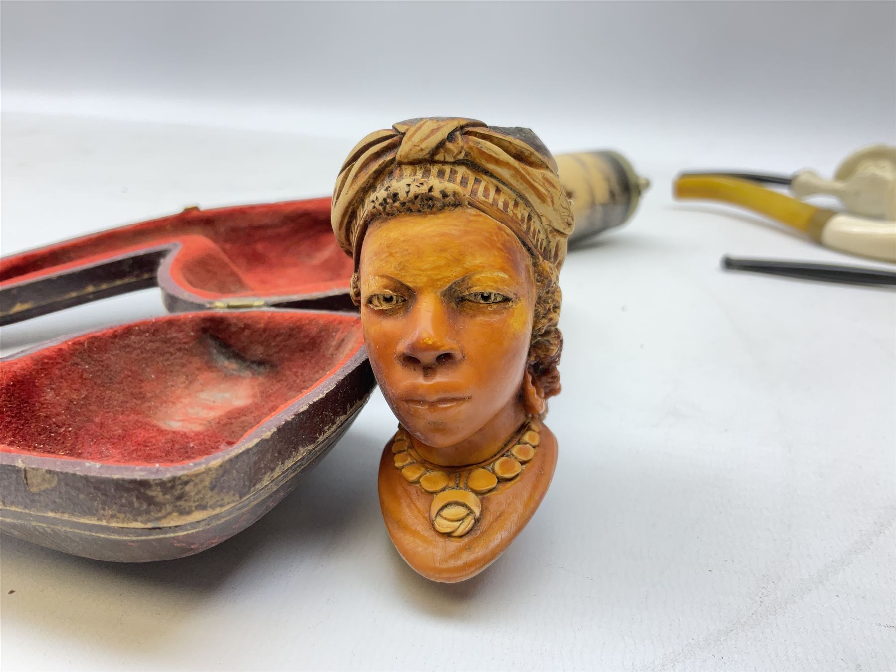 Carved meerschaum and amber pipe with silver mount, the bowl carved as a woman, cased, clay pipe in the form of an acorn, ceramic pipe, five other pipes and a ceramic bottle pourer in the form of a horse  