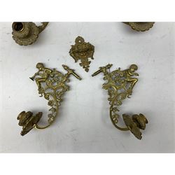 Two ornate brass wall sconces with twin branches modelled with cherubs playing trumpets