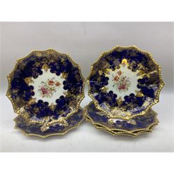 Early 20th century Aynsley dessert service, painted with floral sprays within moulded deep blue and ornate gilt pattern borders, comprising pedestal comport dish, six plates, shell shaped dish and shaped twin handled serving dish, no 4145, all with printed marks beneath