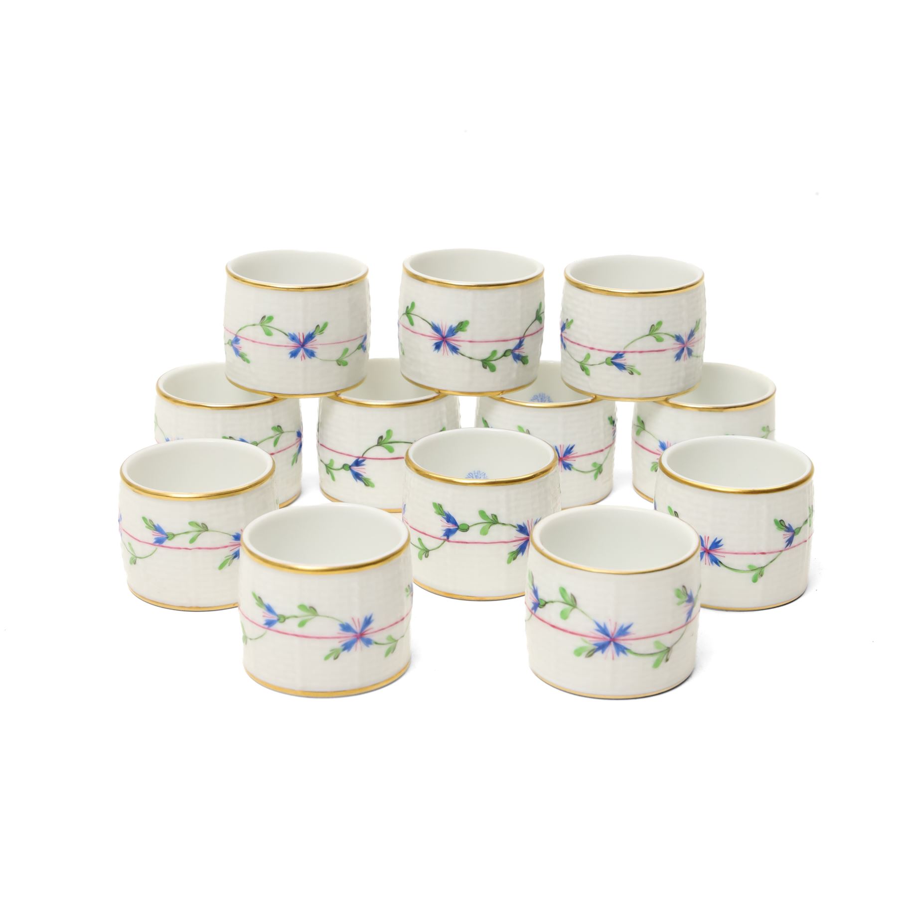 Set of twelve Herend porcelain napkin rings painted with trailing flowers and leaves on a moulded ground