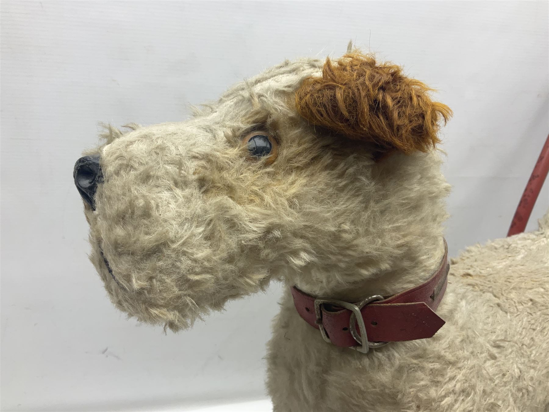 Tri ang - Pedigree Soft Toys - push along/ride-on dog as a wood wool filled plush Airedale terrier in red tubular frame with beech footrests and black rubber wheels; stitched Northern Ireland label in tact L60cm H61cm