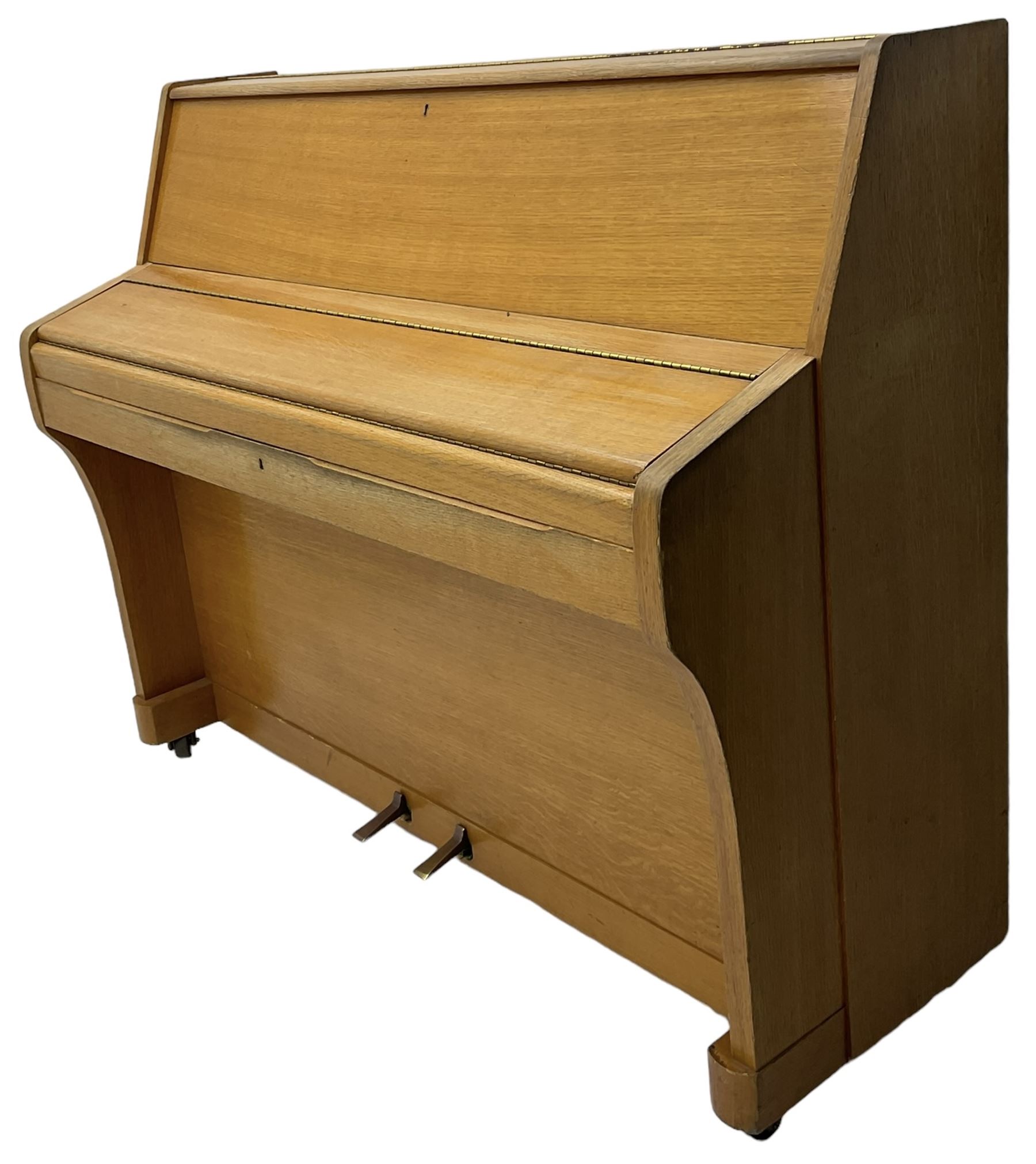 Kemble - English 20th century compact upright piano in light oak case, with an overstrung cast iron frame, underdamper action, original stringing and hammers, with sostenuto and sustain pedals. 88 note compass (7 octaves). 