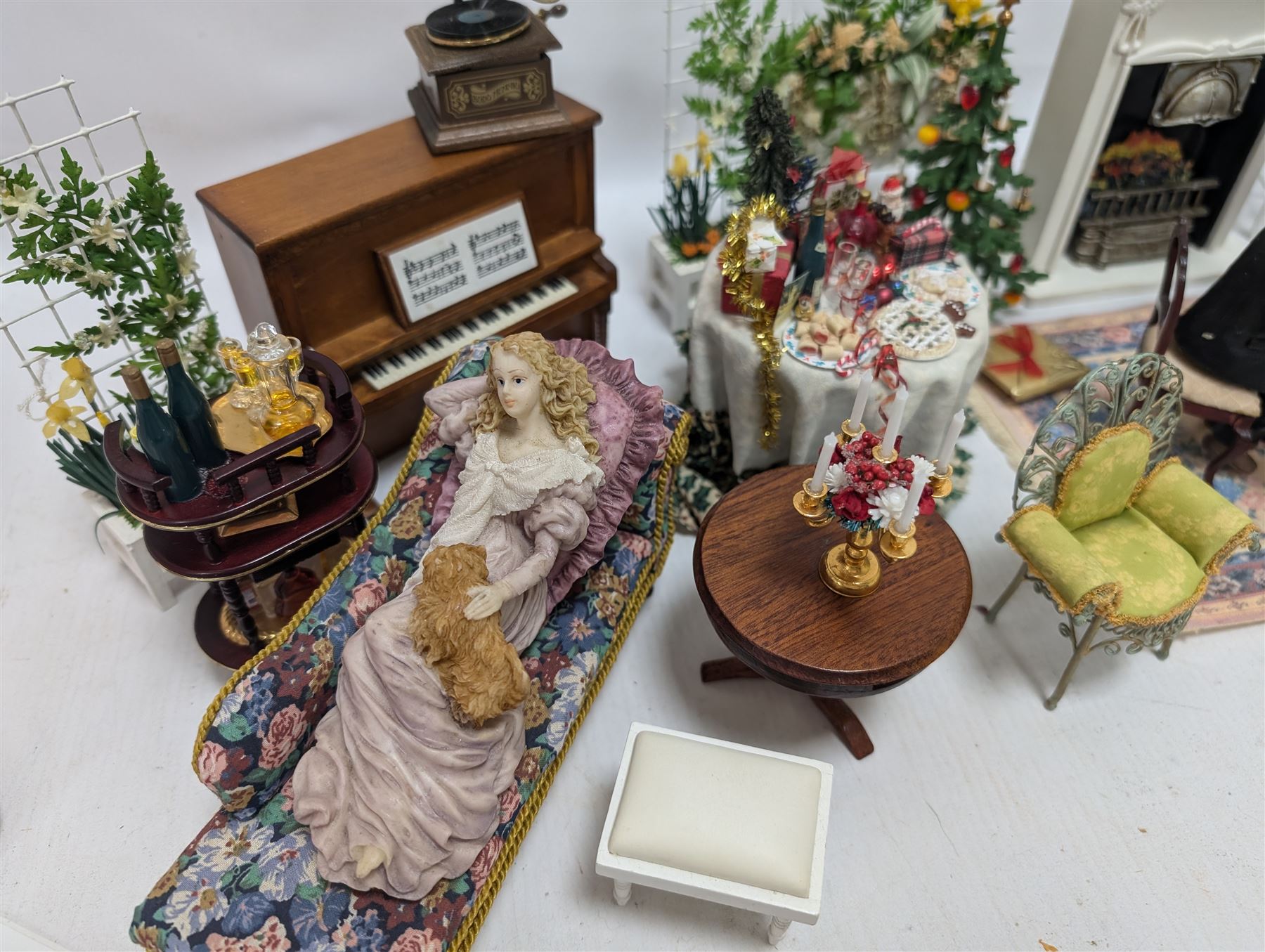 Dolls house furniture, including pianos, fireplace, plants, flower arrangements, tables, chairs, six figures and a collection of instruments and other accessories
