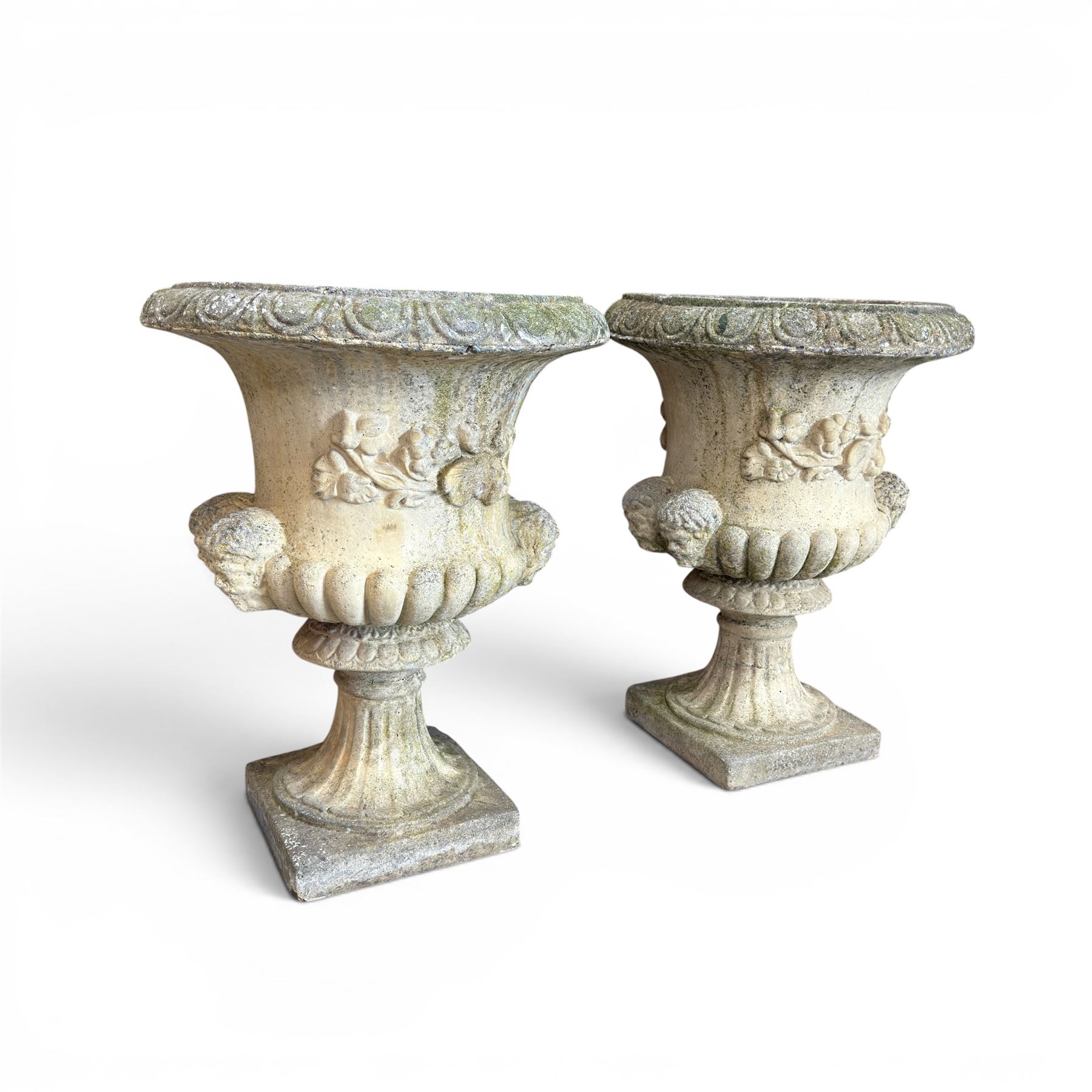 Pair of large cast stone garden urns, circular form with egg and dart border, tapering gadrooned bowl with cast handles and detail