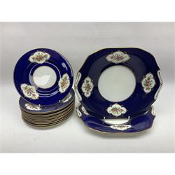Crown Chelsea tea service for twelves, decorated with panels of floral sprigs, with a blue ground, comprising tea cups and saucers, dessert plates, milk jug, open sucrie and two cake plates 