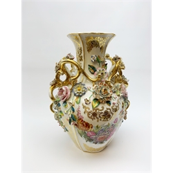 A large Continental vase, of ovoid form with naturalistic modelled twin gilt handles, decorated with a hand painted figural scene and hand painted floral spray, detailed throughout with encrusted flowers and further heightened with gilt, not including associated base H45.5cm. 