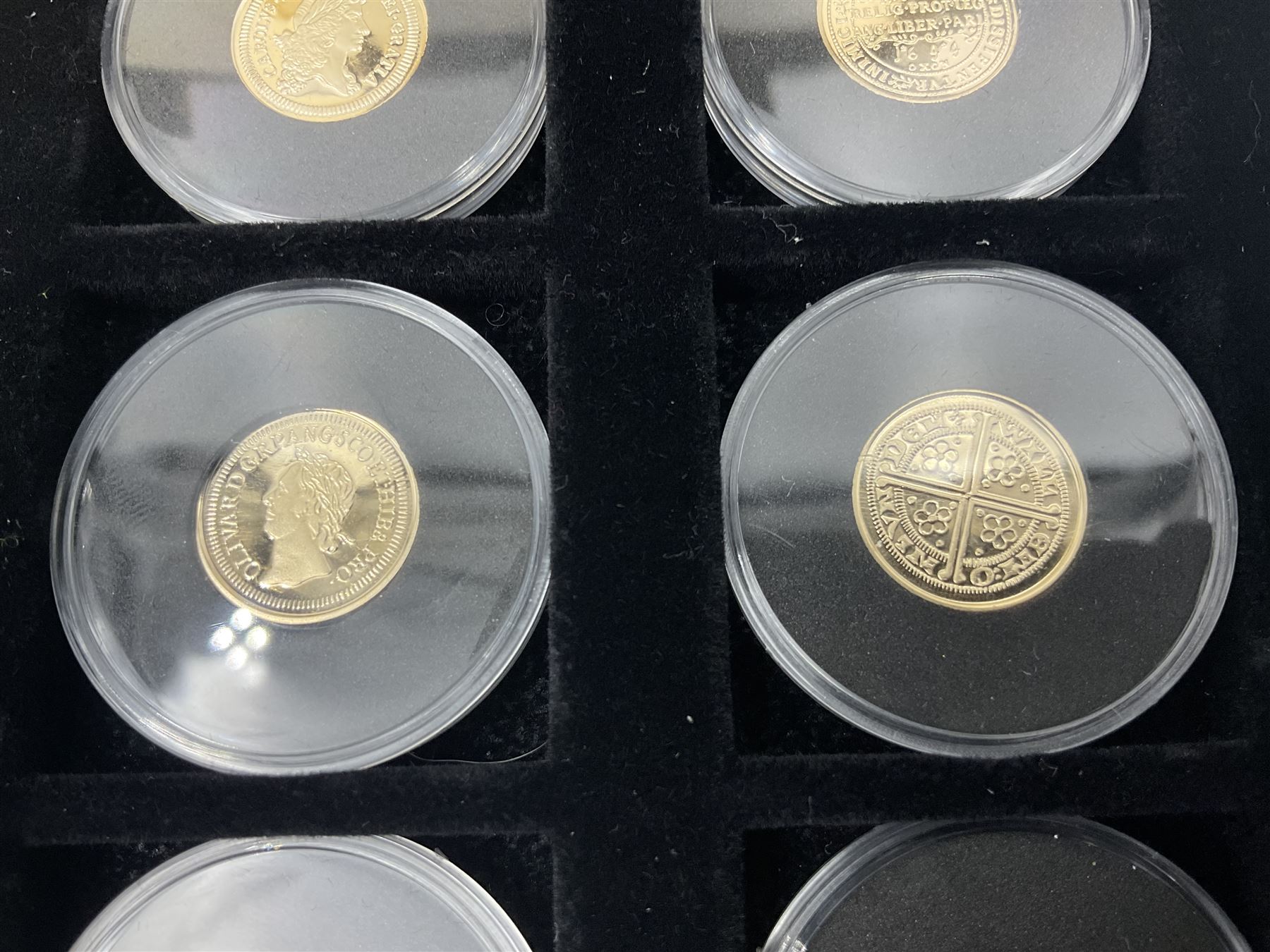 Sixteen hallmarked 9ct gold replica coins from 'The Historic Coins Of Great Britain Museum Gold Collection', housed in a Westminster display case, overall weight approximately 51.3 grams
