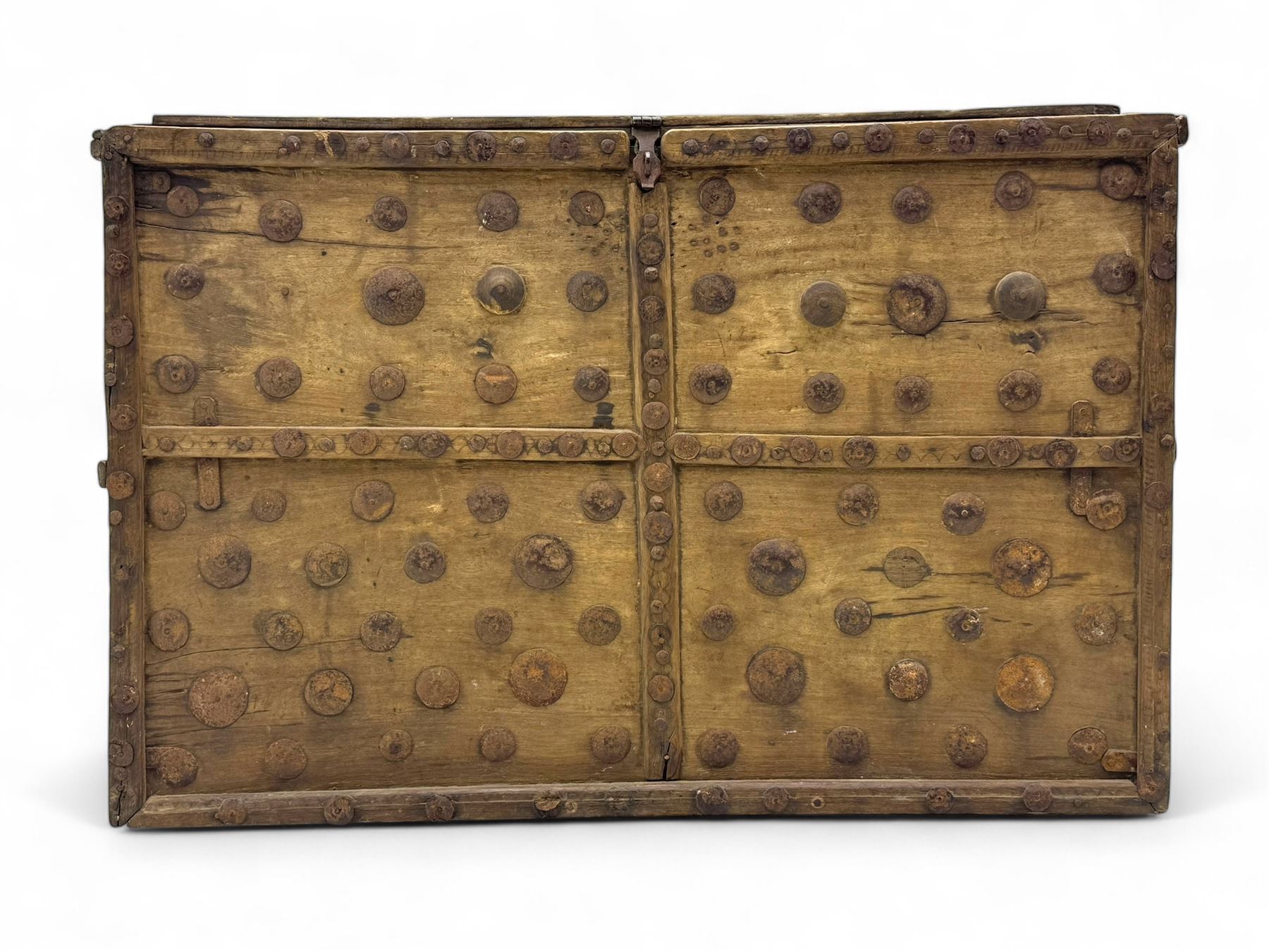 Late 19th century Afghan carved hardwood storage chest, the hinged plank top enclosing large internal storage space, geometric carvings to the front panels decorated with rows of riveted iron bosses