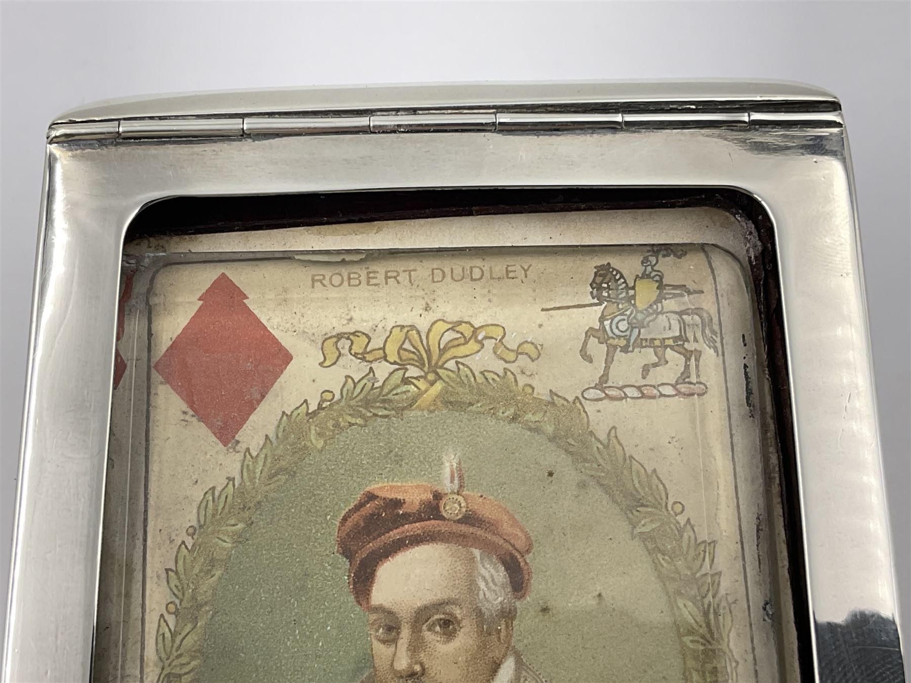 Edwardian silver mounted playing card case, hallmarked William Harrison Walter, Birmingham 1903, the sides each with a period playing card set behind a bevelled glass panel, the hinged cover with later engraving 'Presented to Norman T Crombie Esq by the officers & men of the 31st WR Detachment for services rendered 1917-1918', with red leather lined interior, the three compartments upon a sprung base and containing two later wooden Whist markers, case H12.5cm