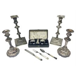 Pair of silver plated Victorian style candlesticks, each of knopped and part fluted form, upon square stepped base, with conforming sconces, together with a smaller pair of silver plated candlesticks, each of knopped and part fluted form, upon lobed foot, a silver plated five piece cruet set, in fitted case and three pieces of mother of pearl flatware, tallest H28.5cm