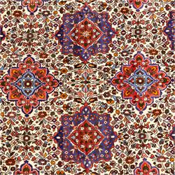 West Persian Hamadan hand-knotted rug, ivory field decorated with a repeating lattice of stylised geometric medallions interspersed with small floral motifs and angular vine ornament enclosed by a sky blue border of stylized rosettes and geometric devices between multiple guard stripes, with cotton fringe ends  