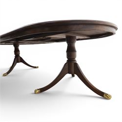 Regency design mahogany extending twin pedestal dining table with two additional leaves, raised on splayed supports terminating brass paw feet
Extends to 268cm