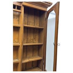 Late 19th century pine dresser, the projecting cornice with dentil and spindle moulded frieze above a three-tier plate shelves, flanked by glazed doors, the base fitted with three frieze drawers over arched apron and carved floral panelled cupboard doors, raised on turned feet