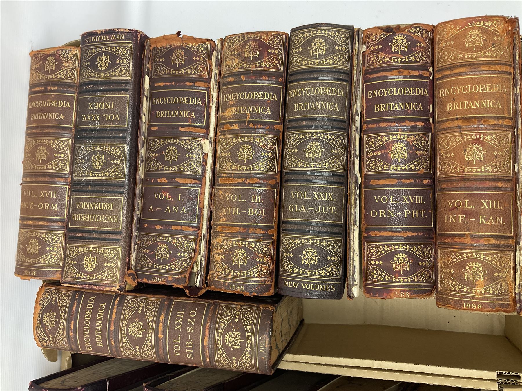 Thirty six volumes of Encyclopaedia Britannica with gold tooled red leather spines in various editions 