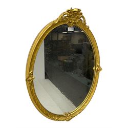 Victorian design gilt framed oval wall mirror, cartouche pediment with extending foliate decoration and C-scrolls, the lower edge moulded with fruit garlands