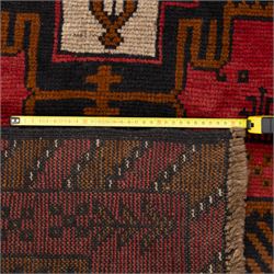 Turkish Anatolian rug, crimson ground, with stepped geometric medallions in ivory, brown, and black within angular striped borders in tones of red and ochre 