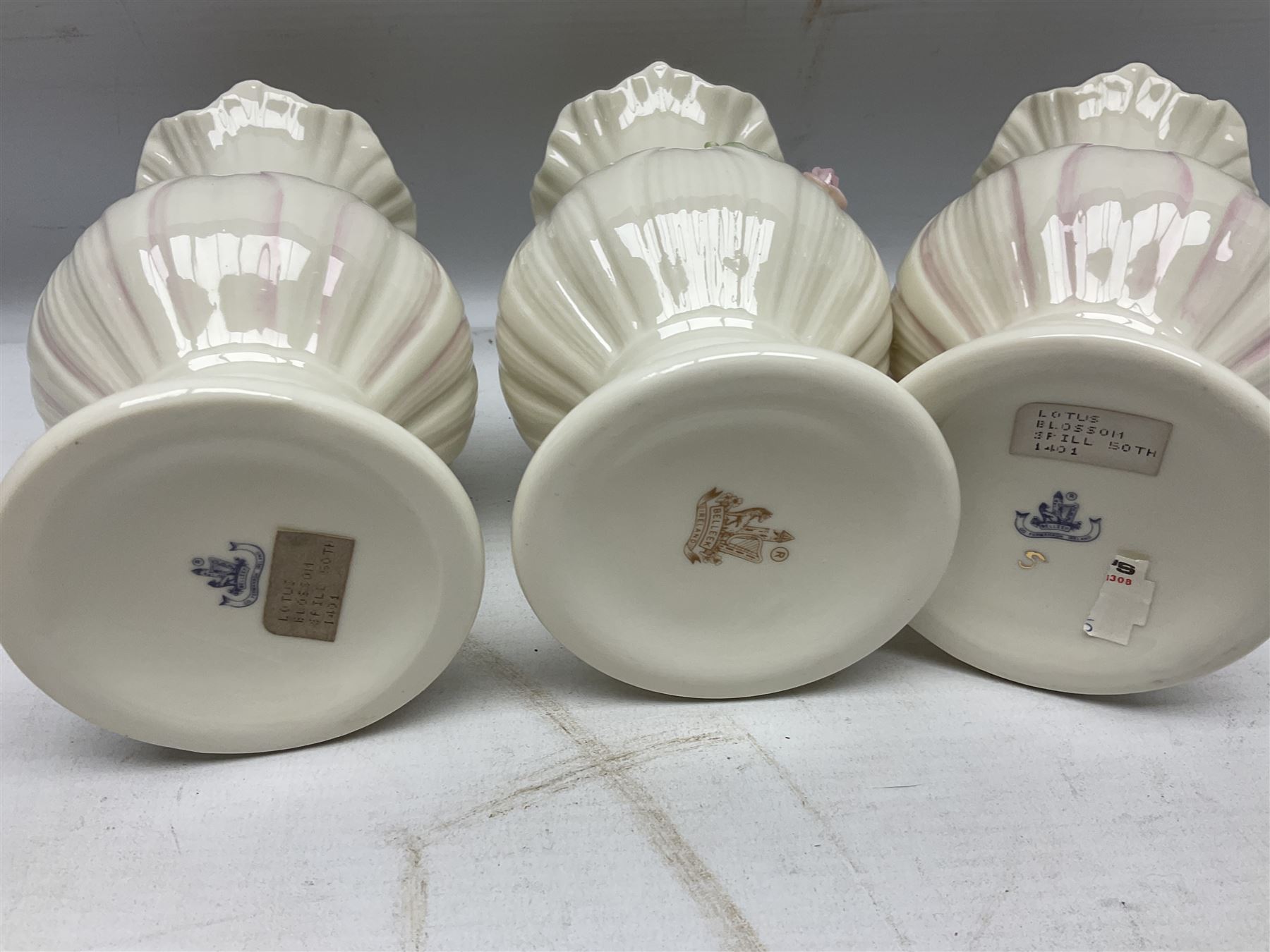 Five late 19th/early 20th century and later Belleek vases, comprising pair of Lotus Blossom examples, shamrock tree trunk vase, twin handled shamrock vase and a baluster form vase decorated with applied roses, all with printed marks beneath, tallest H16cm