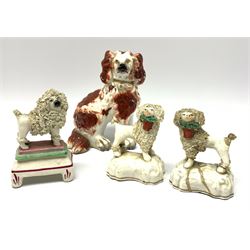 A pair of Victorian Staffordshire figures modelled as poodles, each carrying basket of flowers, together with a further Staffordshire poodle figure, and a 19th century Staffordshire Spaniel with separate front legs, H13.5cm. (5). 