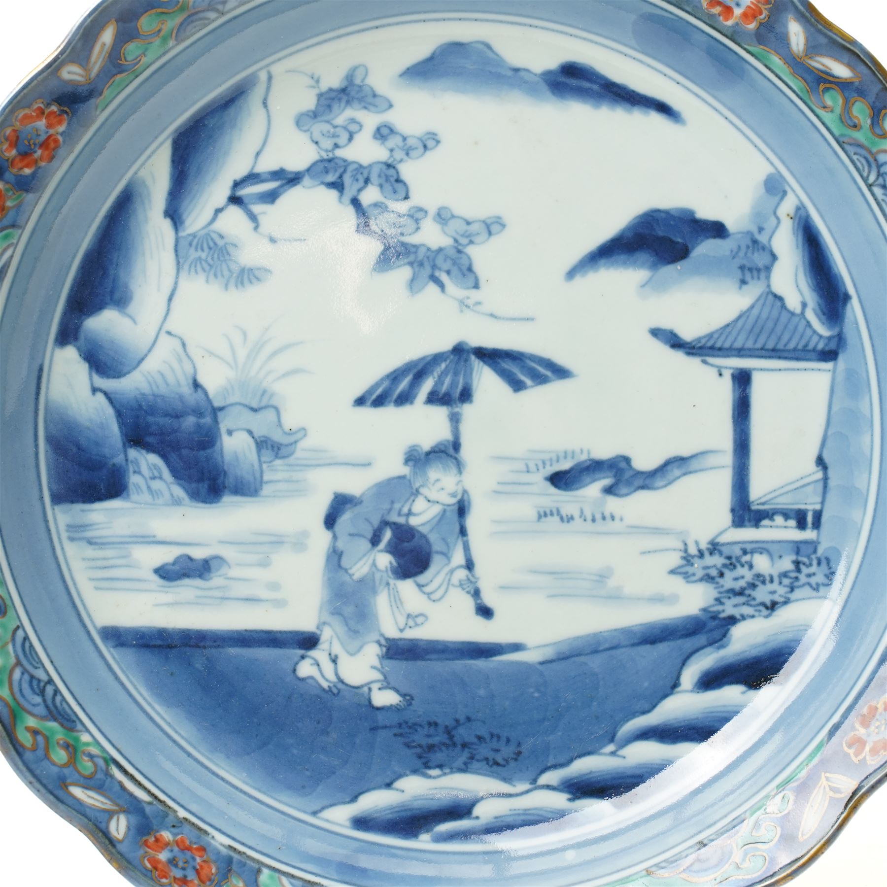 Japanese 19th century Arita style dish, painted centrally in blue and white with a lady carrying peaches, marked in blue to base, W28.5cm 