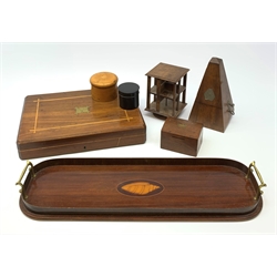 An Edwardian mahogany tray with twin brass handles and inlaid shell detail to centre, L54.5cm, a miniature revolving table top bookcase, H15.5cm, small 19th century money box, 19th century sycamore cylindrical box and cover, similar form ebonised box and cover, a 20th century Metronome by Maelzel, and mahogany flatware box with vacant brass plaque to hinged cover, (lacking interior fittings). (7). 