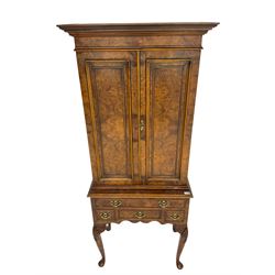 Queen Anne style figured walnut drinks cabinet on stand, two doors enclosing mirrored interior with shelves and slide, the stand fitted with four drawers on shell carved cabriole legs