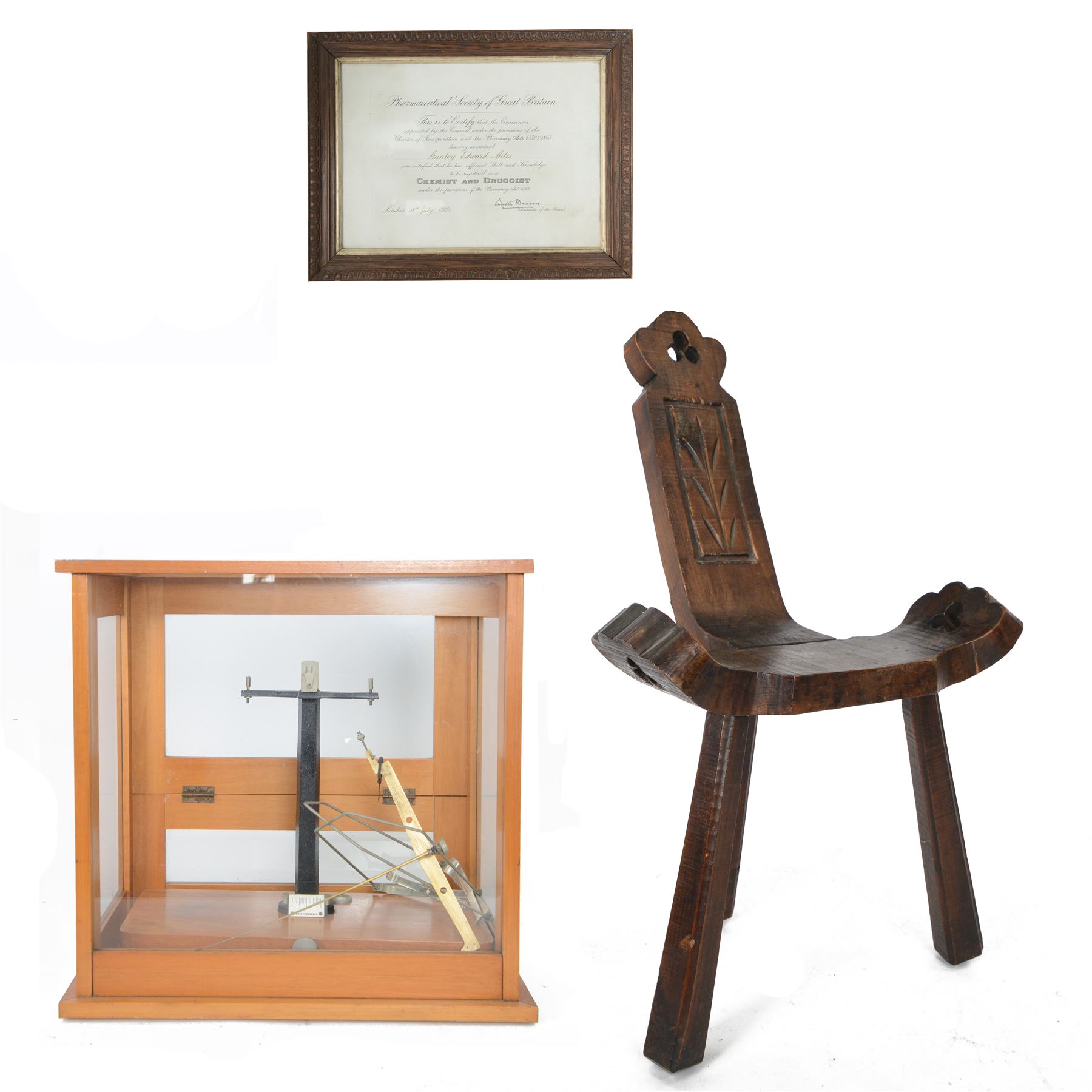Carved birthing stool on three legs, together set of cased balance scales and framed certificate for Pharmaceutical Society of Great Britain 
