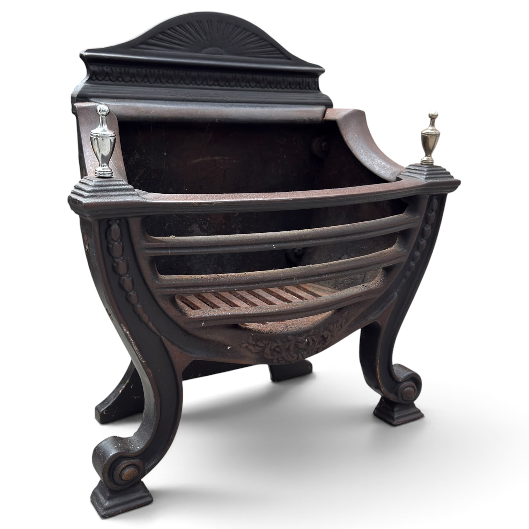Three cast iron fireplace fittings, comprising a Regency-style fire grate with sunburst crest, urn finials, bowed basket and scroll supports (W58cm H63cm); Victorian fender with pierced acanthus frieze and foliate base (W64cm H20cm); Gothic Revival fireplace with fleur-de-lis crest, arched surround and integral fire basket (W41cm H87cm)