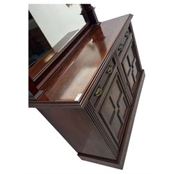 Victorian mirror back press, the arched corniced mirror back flanked by half columns, the base fitted with three drawers and four moulded panel doors with geometric detail, on a block plinth