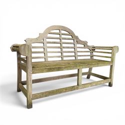 Lutyens design weathered teak garden bench with matching two-tier table, the bench with shaped arched and slatted back over rolled arms and slatted seat