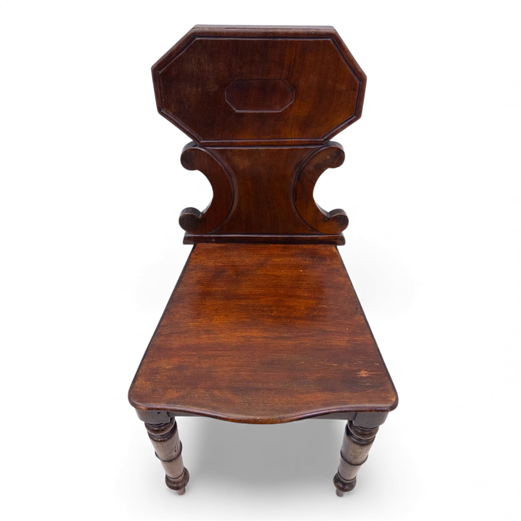 Pair of 19th century mahogany hall chairs, each with shaped octagonal backrest featuring a recessed cartouche panel, serpentine supports and moulded seat, raised on turned front legs