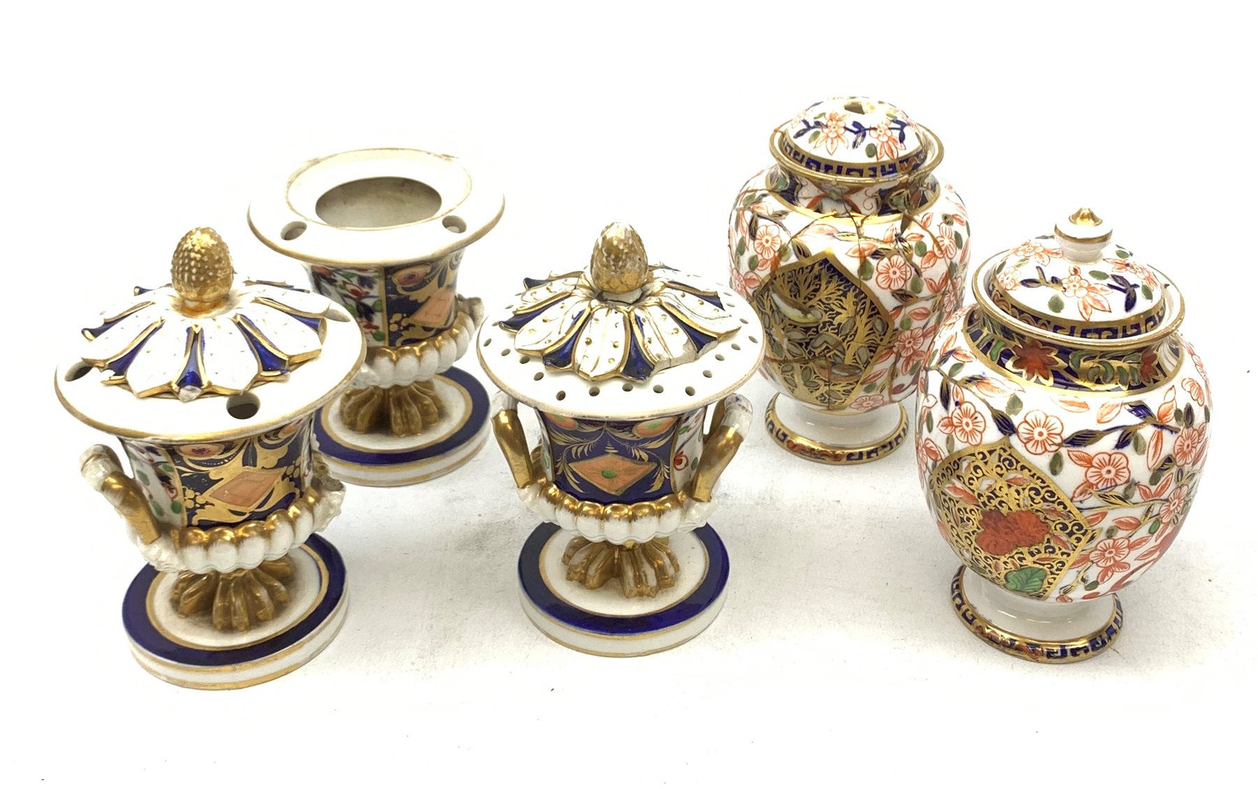Three Bloor Derby Imari pattern twin handle urms, two examples with covers, each with mark beneath, H12cm, (all a/f), together with a pair of late 19th century Royal Crown Derby Imari pattern urns and covers, each with mark beneath, H13cm, (one significantly a/f). 